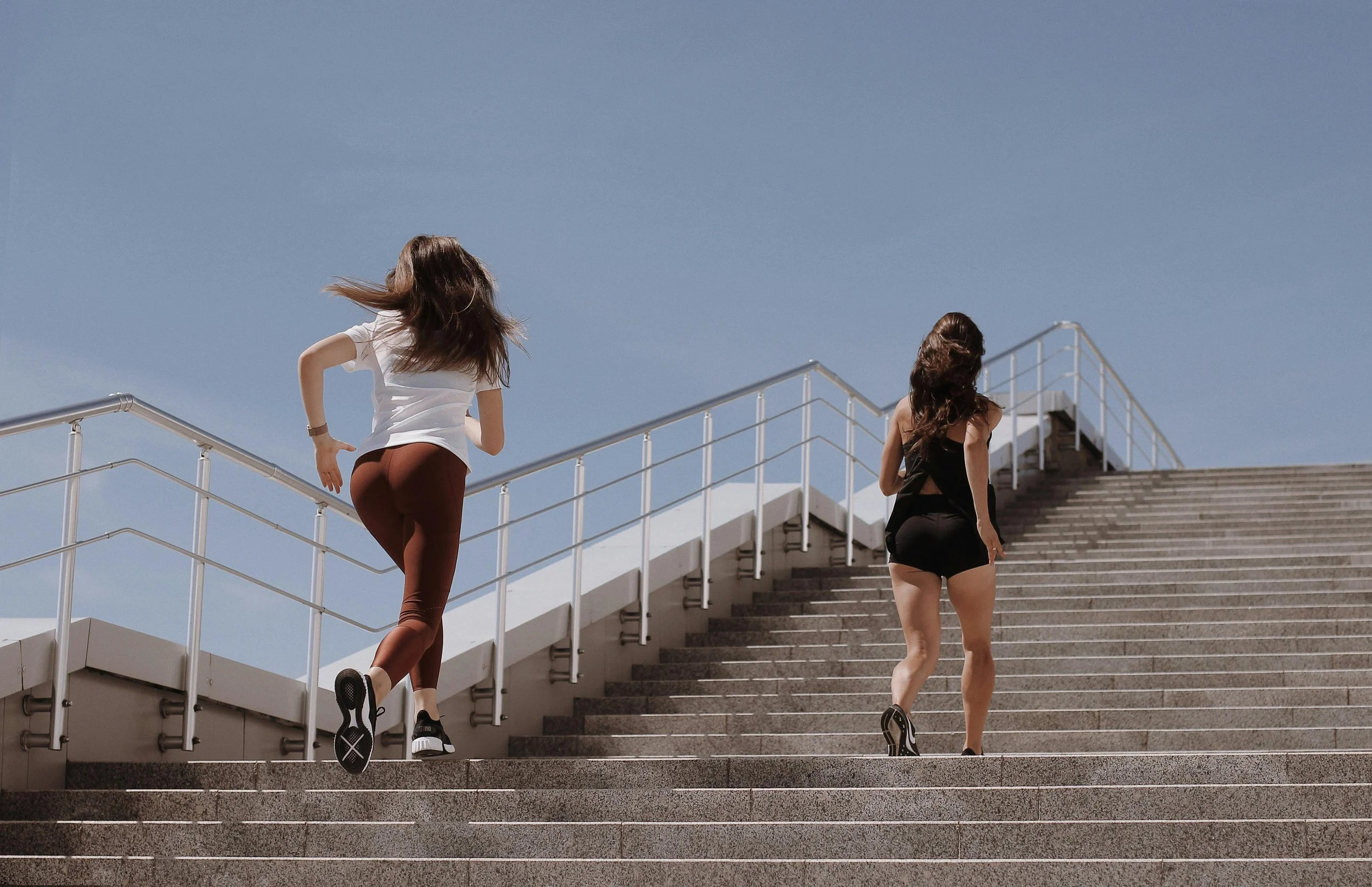 Two people running up a flight of stairs