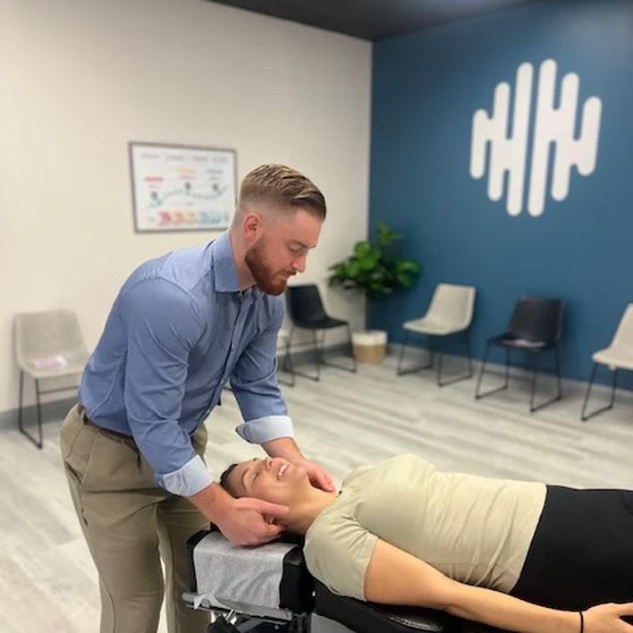 A doctor performing a neck adjustment in the clinic