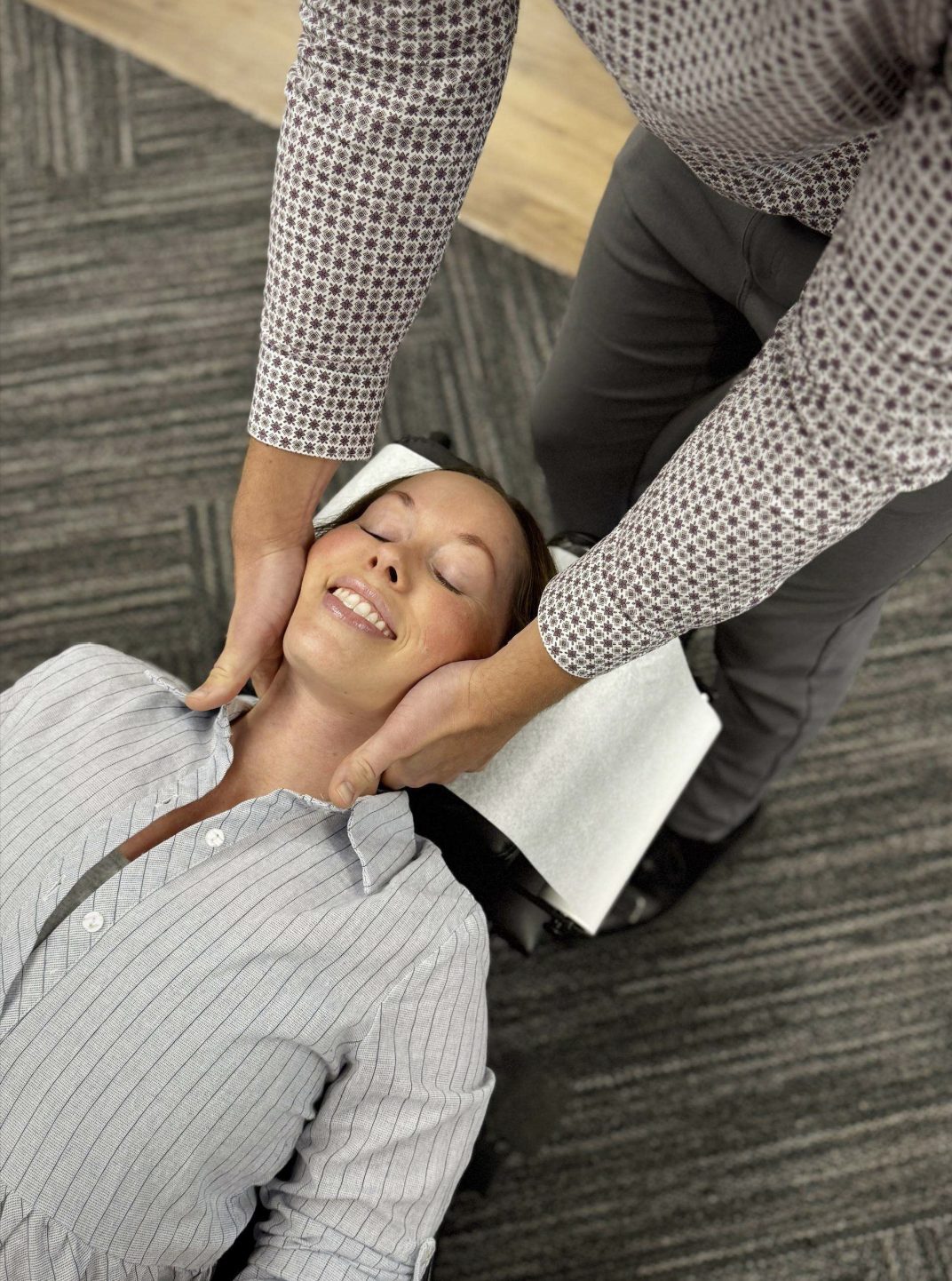 A patient smiling during a neck adjustment at Ability Chiropractic